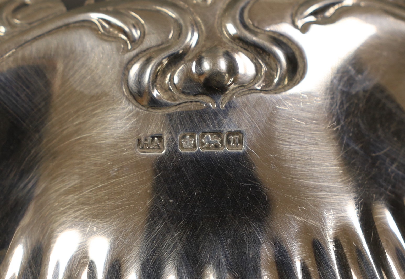 An Edwardian Art Nouveau silver shell dish, with pierced handle, on ball feet, Atkin Brothers, Sheffield, 1905, 28.3cm, together with two small pairs of repousse silver bonbon dishes, 16oz.